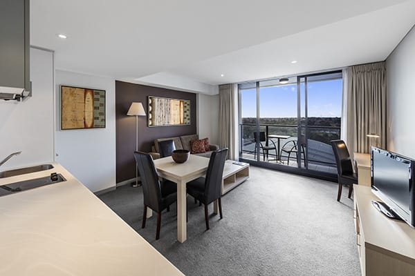 large air conditioned living room opening to private balcony with views of Adelaide Oval and Karrawirra Parri river