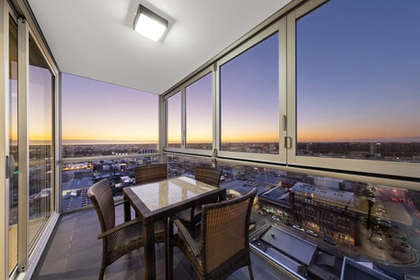 iStay Precinct hotel Adelaide CBD 2 bedroom apartment balcony with delicious vegetarian dinner off menu and views of Adelaide city centre at dusk
