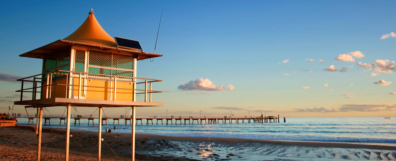 lifeguard watch tower on glenelg beach at sunset on beach close to a Glenelg hotel by Oaks Hotels and Resorts in South Australia during summer holidays