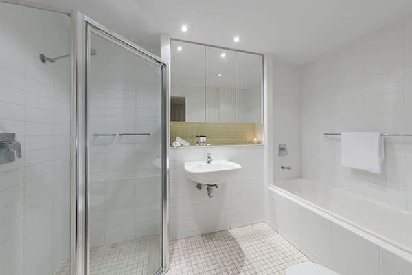 en suite bathroom with clean towels, disabled access shower and large mirror in 1 bedroom apartment at Oaks Liberty Towers hotel in Glenelg