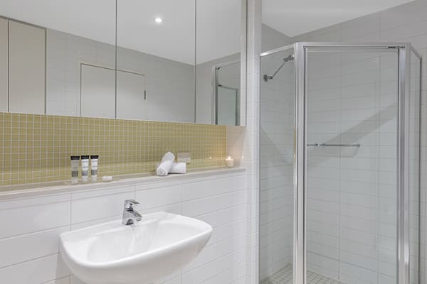 large shower, toilet and sink in en suite bathroom of 2 bedroom hotel apartment near Glenelg beach, South Australia
