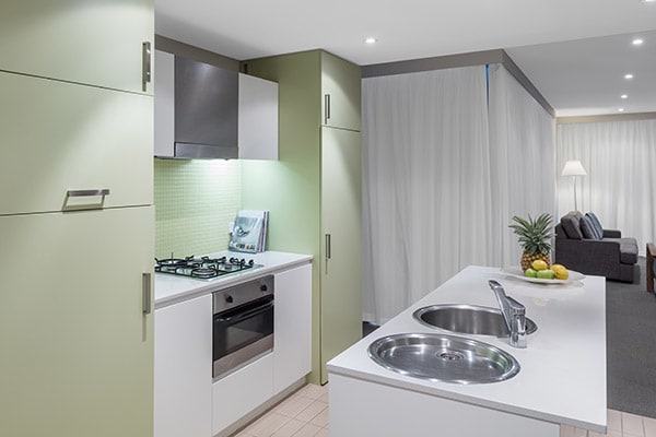 kitchen with stove, oven and counter top for preparing vegetarian meals at Oaks Liberty Towers hotel in Glenelg, South Australia