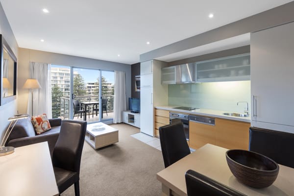 big living room with air conditioning, Foxtel on TV and 30 minutes free Wi-Fi in 1 bedroom park view apartment at Oaks Plaza Pier hotel on Glenelg Beach, South Australia