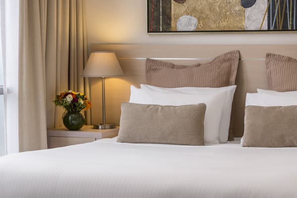 close up view of comfortable pillows on clean white sheets of double bed in Studio Apartment at Oaks On Lonsdale hotel in Melbourne city, Victoria, Australia