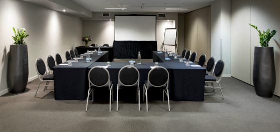 air conditioned room with large projector screen, tables and chairs in air conditioned conference room for hire in Melbourne city