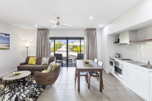 spacious living room with ceiling fan, air conditioning and kitchenette with microwave, oven, toaster and fridge in 1 Bedroom hotel apartment in Broome, Western Australia