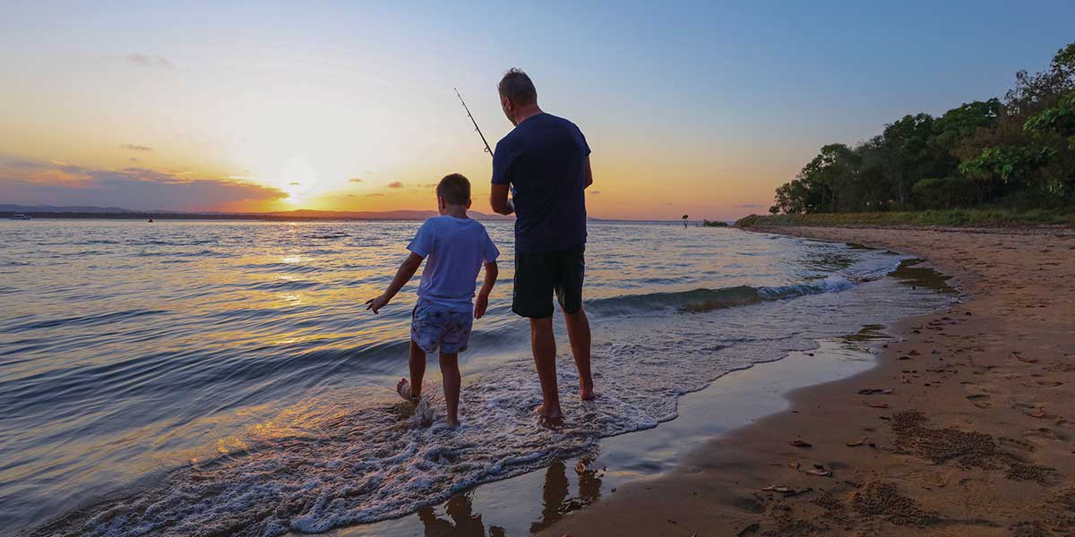 Father and son fishing by the shoreline of Southern Great Barrier Reef in Gladstone Queensland