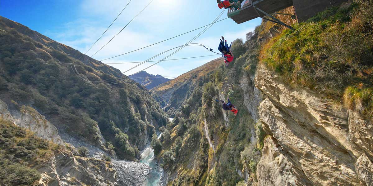 Adventurers released from the edge at the Shotover Canyon Swing