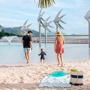 Family enjoying vacation at the Cairns Esplanade Lagoon with white fine sand and clean blue waters