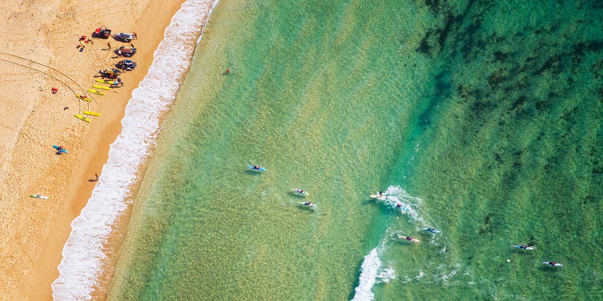 People enjoying water activities at the clear blue waters of Toowoon Bay, The Entrance