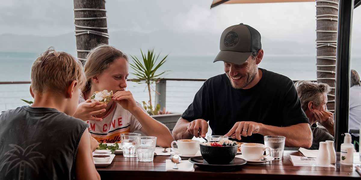 A family enjoying lunch at The Strand with picturesque view of Townsville's beachside