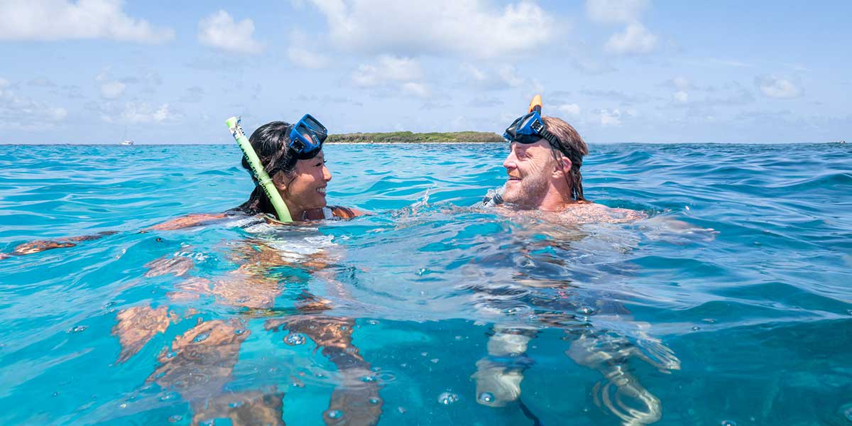 Swimmers enjoying the Lady Musgrave Snorkeling Experience in the blue waters of the Great Barrier Reef 