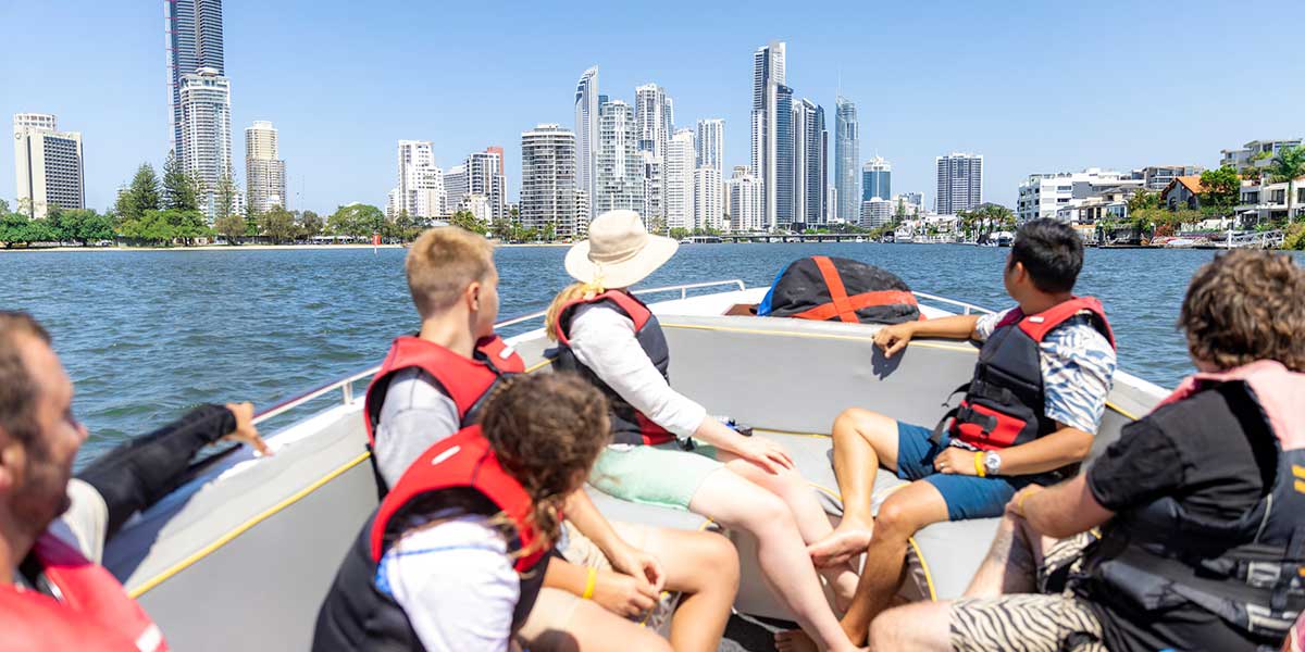 Group of friends on the boat strolling in the middle of Gold Coast 