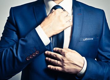 new employee tying tie wearing blue suit