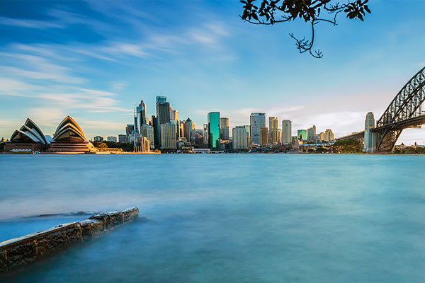 view of Sydney Opera House in the morning with Harbour Bridge and city centre in the background during summer in New South Wales, Australia