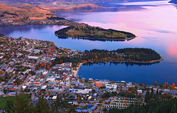 panoramic view of Queenstown at sunrise from balcony of Oaks Shores restaurant in Otago, New Zealand