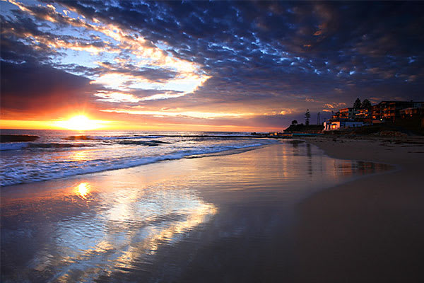 The Entrance hotel near beach in New South Wales at sunset offers the best Central Coast accommodation with tourists on holiday walking near the ocean, Australia