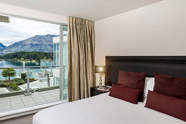 comfortable double bed in large 1 Bedroom Apartment with free Wi-Fi access and private balcony at Oaks Club Resort hotel in Queenstown, New Zealand