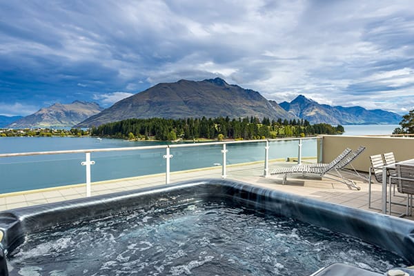 hot tub, spa bath jacuzzi on private balcony of 2 Bedroom Apartment with views of Lake Wakatipu and The Remarkables mountain range at Oaks Club Resort hotel in Queenstown, New Zealand