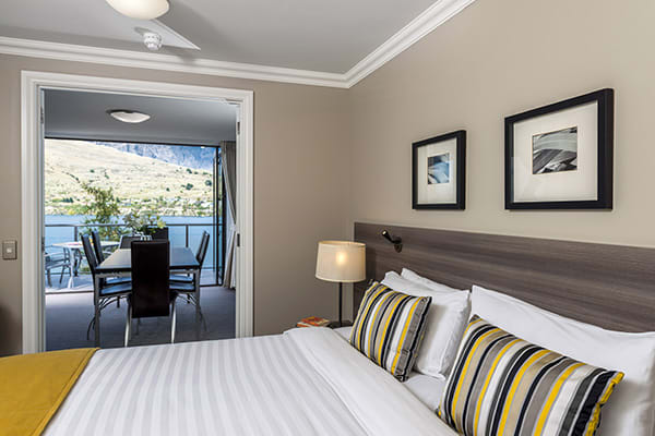 comfortable double bed with big pillows and clean sheets in master room with Wi-Fi in 2 bedroom holiday apartment at Oaks Shores hotel in Queenstown, New Zealand