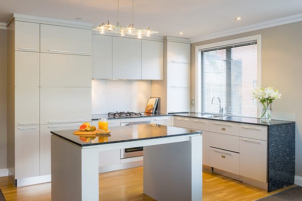 open plan kitchen with bench tops, microwave, stove top hot plates, oven and dishwasher in 2 Bedroom Lake View Apartment at Oaks Shores hotel in Queenstown, New Zealand