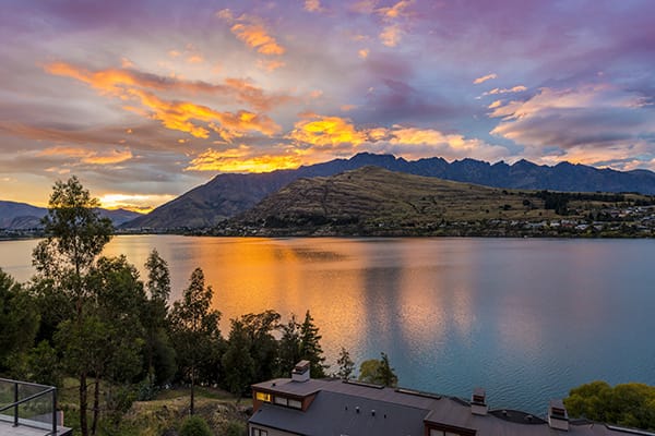 beautiful sunset over The Remarkables mountain range and Lake Wakatipu during summertime in Queenstown, New Zealand