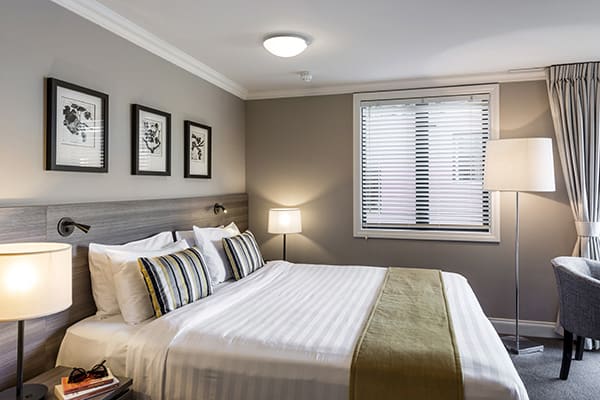 close up view of queen size bed in bedroom with table and office chair for corporate travellers to do work on while visiting Queenstown on a business trip