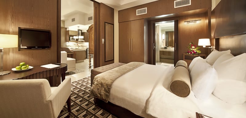 comfortable king size bed with big pillows in Deluxe Superior suite with en suite bathroom and Wi-Fi at Oaks Liwa Executive Suites hotel in Abu Dhabi, United Arab Emirates